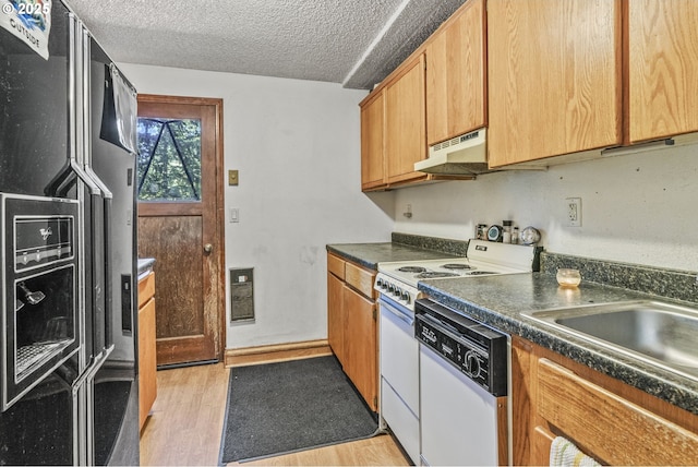 kitchen featuring light wood-type flooring, sink, a textured ceiling, and white appliances