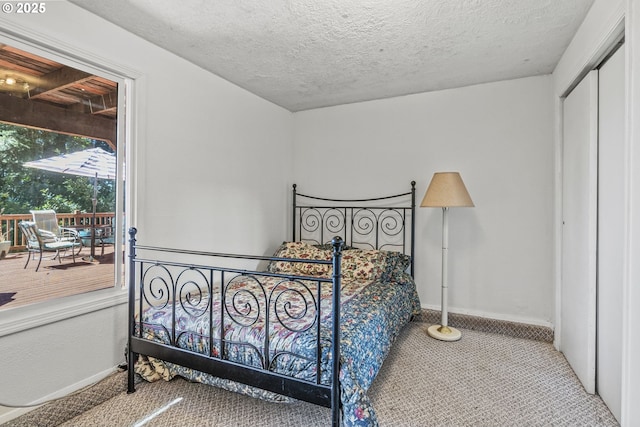 carpeted bedroom with a textured ceiling and a closet