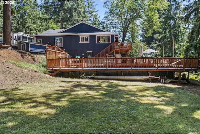 rear view of property featuring a deck and a yard