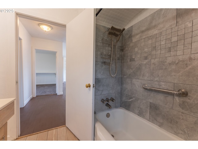 bathroom with tub / shower combination, wood finished floors, and vanity