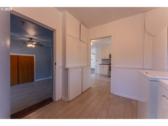 washroom featuring light wood-style floors, a ceiling fan, and washing machine and dryer