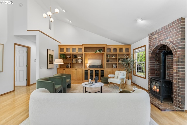 1281 NE Zachary St, Hillsboro, OR 97124 - living area with a wood stove, light wood-style flooring, high vaulted ceiling, and baseboards
