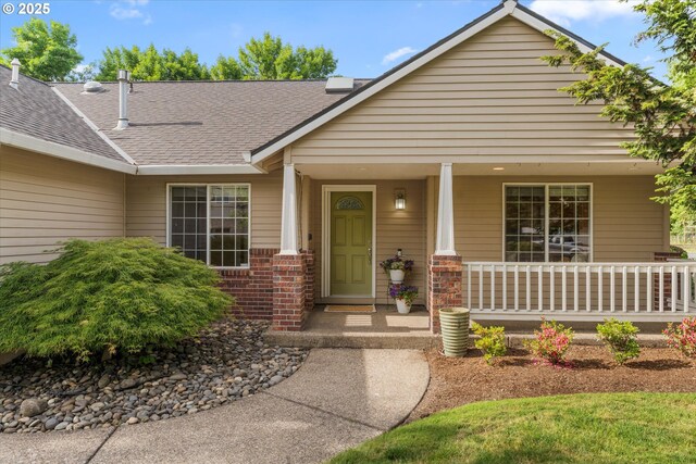 1281 NE Zachary St, Hillsboro, OR 97124 - property entrance with a porch, a shingled roof, and brick siding