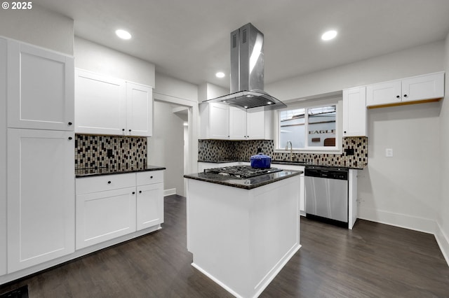 kitchen with island range hood, white cabinets, dark wood-style floors, appliances with stainless steel finishes, and a sink