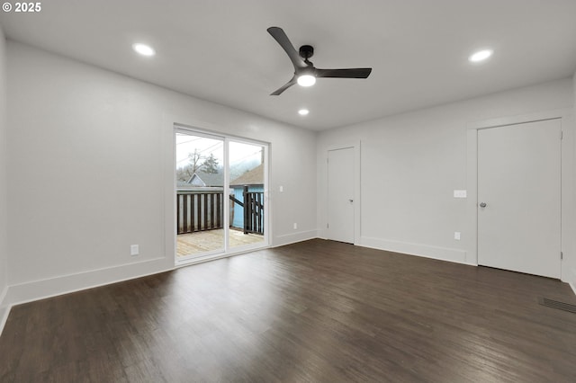 empty room with dark wood-style floors, recessed lighting, visible vents, and baseboards