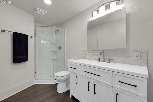 bathroom with toilet, wood finished floors, visible vents, backsplash, and a shower stall