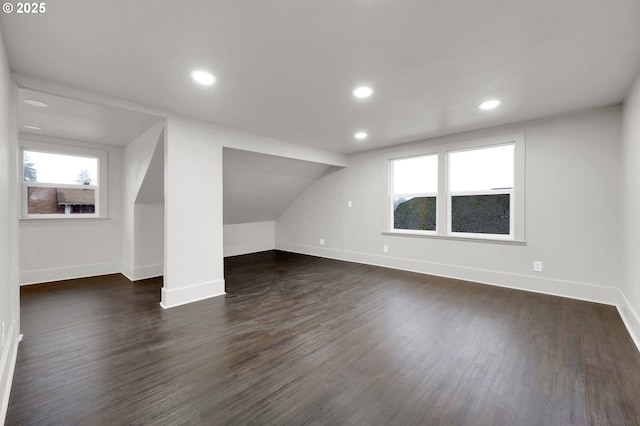 bonus room featuring a healthy amount of sunlight, baseboards, and dark wood-style flooring