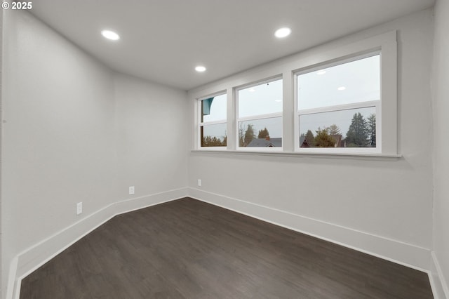 unfurnished room featuring dark wood-type flooring, recessed lighting, and baseboards