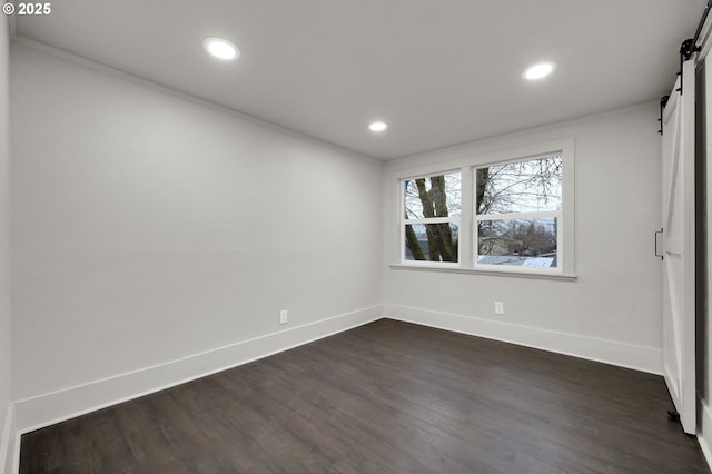 311 N 9th St, Cottage Grove, OR 97424 - empty room featuring a barn door, recessed lighting, baseboards, dark wood-style flooring, and ornamental molding