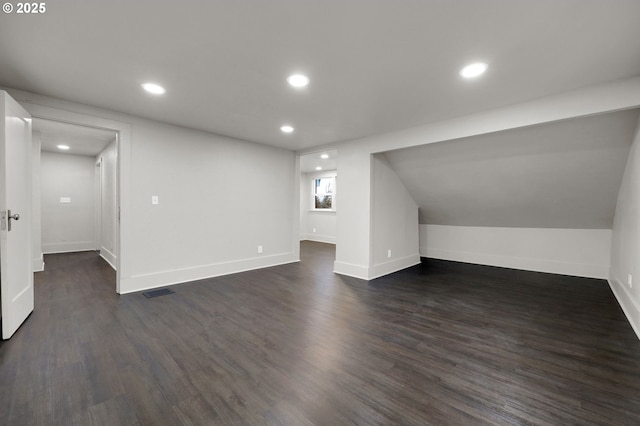 additional living space featuring visible vents, baseboards, dark wood-style flooring, and recessed lighting