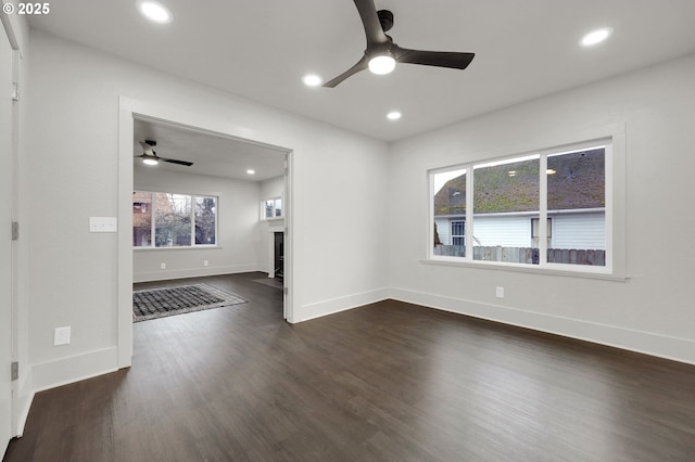 unfurnished room with baseboards, a ceiling fan, a fireplace with flush hearth, dark wood-style flooring, and recessed lighting