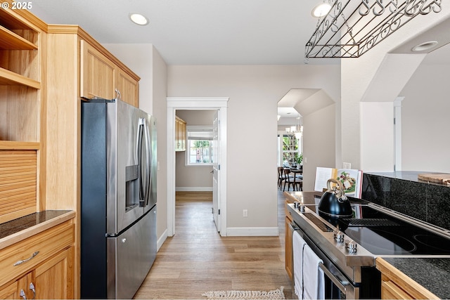 3301 Parker Ln, Springfield, OR 97477 - kitchen featuring stainless steel fridge, stove, open shelves, arched walkways, and light wood finished floors