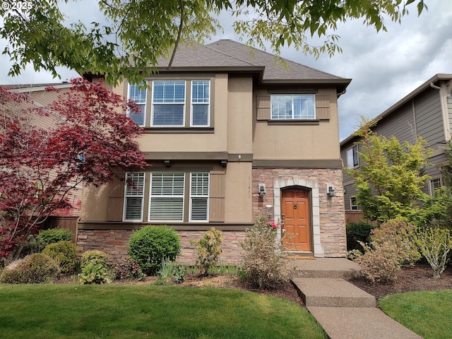 view of front of home with stone siding, stucco siding, a front lawn, and a shingled roof