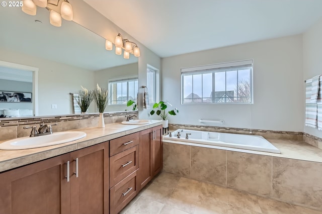 bathroom with a bath and double vanity