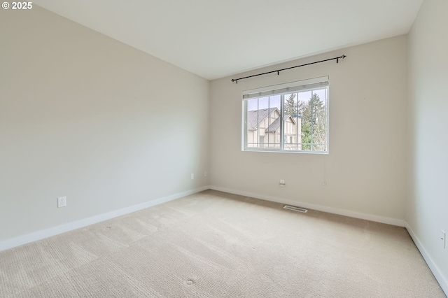 empty room with baseboards and light carpet