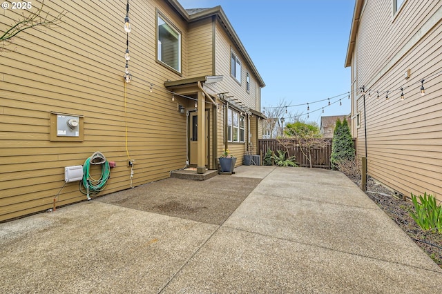 view of side of home featuring a patio and fence