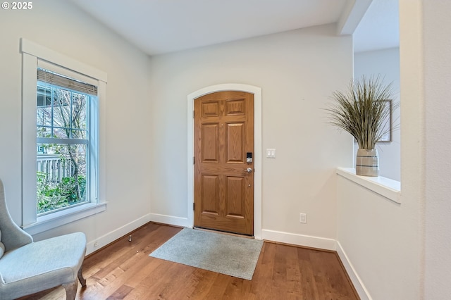 foyer with baseboards and wood finished floors