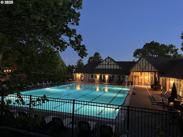 community pool with a patio area and fence