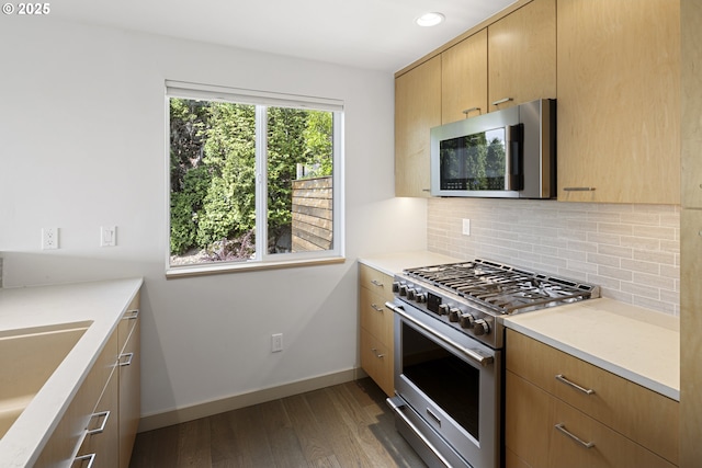 8630 SW 61st Ave, Portland, OR 97219 - kitchen with stainless steel appliances, decorative backsplash, dark wood-type flooring, light countertops, and a sink