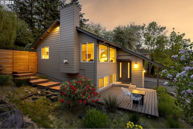 8630 SW 61st Ave, Portland, OR 97219 - back of property at dusk with a chimney, fence, and a deck