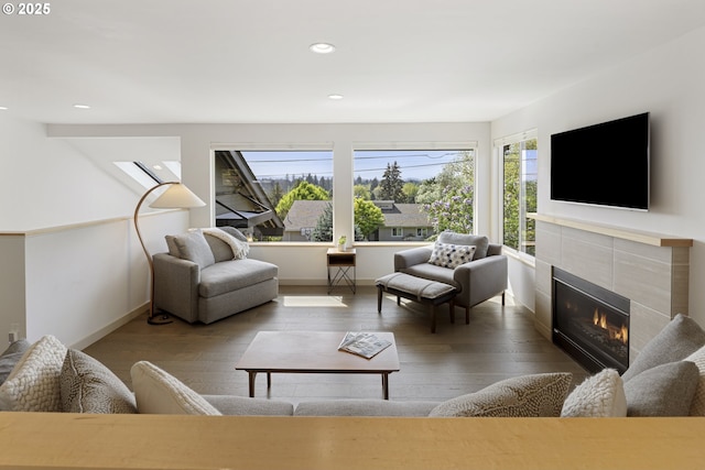 living room featuring recessed lighting, wood finished floors, a wealth of natural light, and a tile fireplace