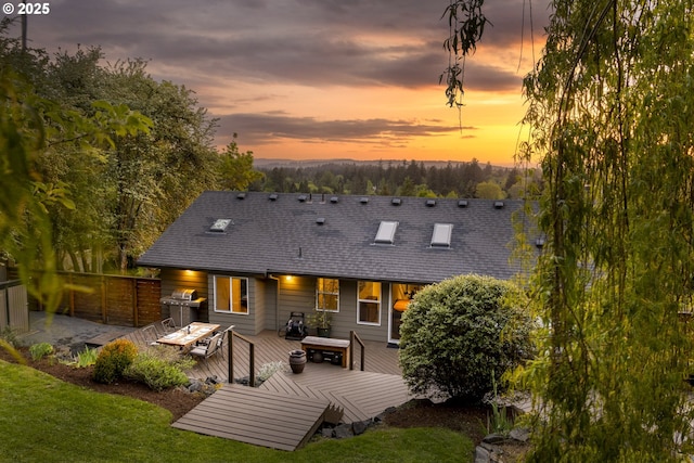 8630 SW 61st Ave, Portland, OR 97219 - back of property at dusk with a deck, a shingled roof, and a lawn