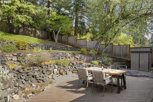 8630 SW 61st Ave, Portland, OR 97219 - wooden terrace with outdoor dining space, a fenced backyard, a storage shed, and an outbuilding