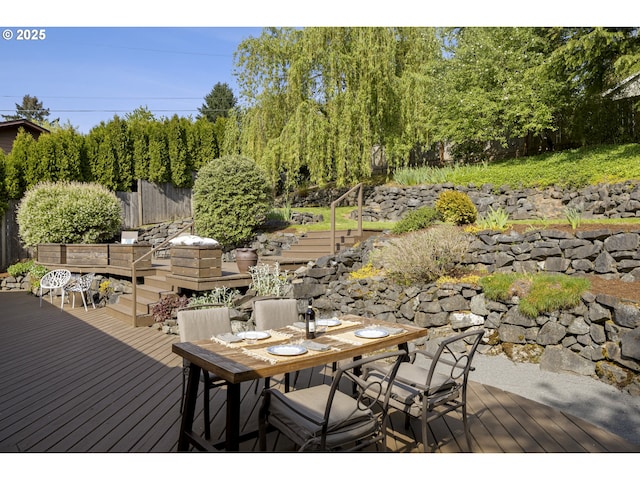wooden deck with fence, outdoor dining space, and stairway