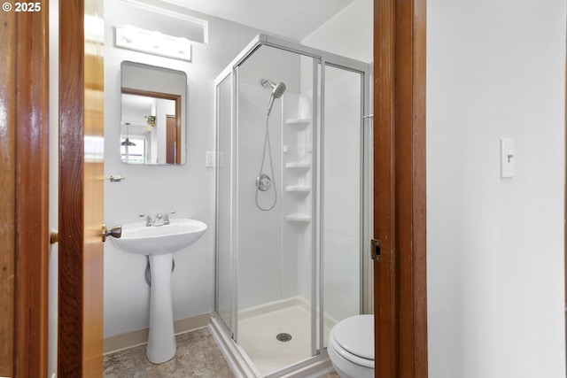 bathroom featuring toilet and a stall shower