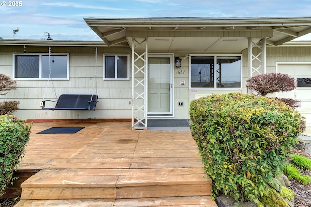 view of exterior entry with a wooden deck