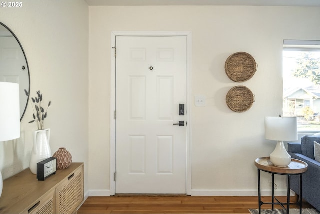 foyer entrance featuring baseboards and wood finished floors