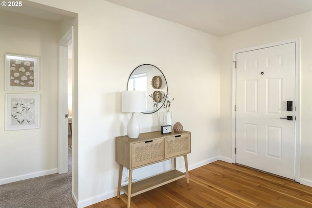 foyer entrance with baseboards and wood finished floors