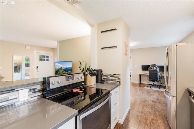 6926 SE Deardorff Rd, Portland, OR 97236 - kitchen featuring stainless steel appliances, wood finished floors, an office area, and white cabinetry