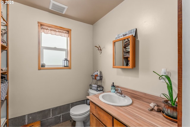 half bathroom with visible vents, toilet, and vanity