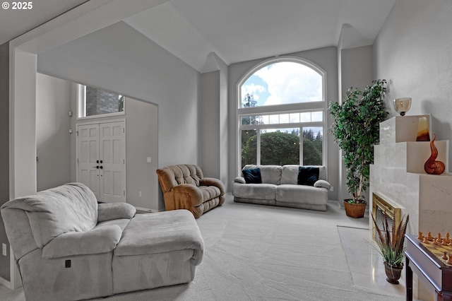 carpeted living area featuring lofted ceiling and a tile fireplace