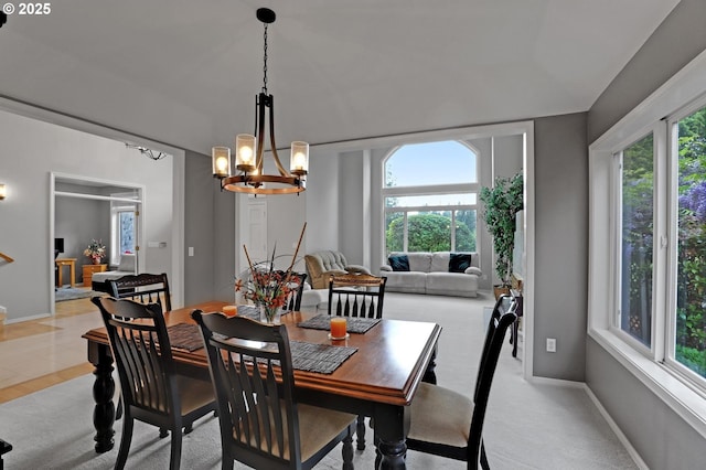 dining space featuring healthy amount of natural light, a chandelier, and baseboards