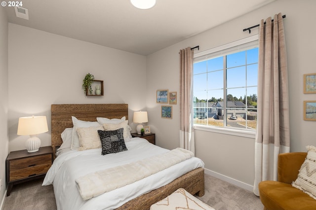 bedroom featuring baseboards, visible vents, carpet floors, and multiple windows