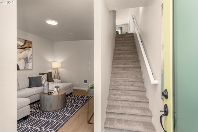 staircase with recessed lighting, visible vents, wood finished floors, and baseboards
