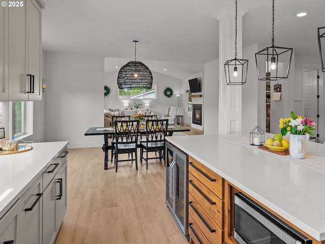 3595 Balm St S, Salem, OR 97302 - kitchen with light countertops, stainless steel microwave, light wood-style floors, hanging light fixtures, and wine cooler