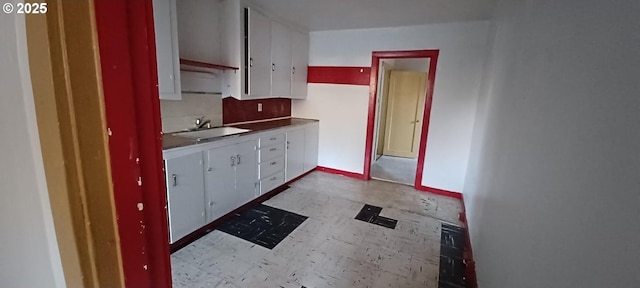 252 5th St, Glendale, OR 97442 - kitchen featuring a sink, light floors, white cabinetry, and baseboards