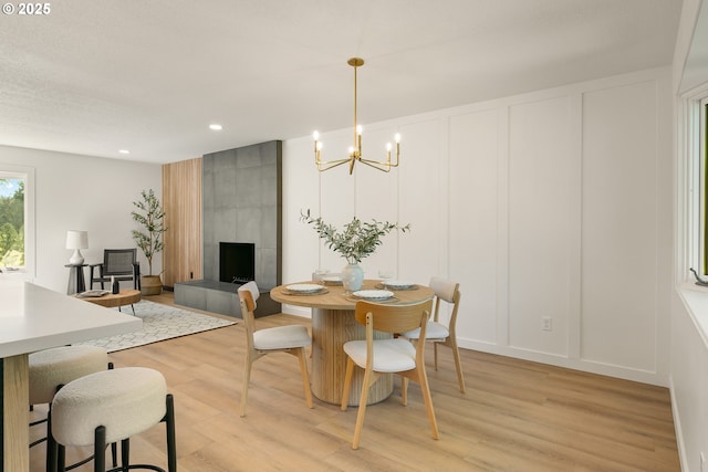 17349 Banyan Ln, Lake Oswego, OR 97034 - dining room featuring a decorative wall, light wood finished floors, a chandelier, recessed lighting, and a tile fireplace