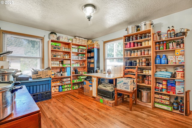 home office featuring a textured ceiling and light wood-style floors