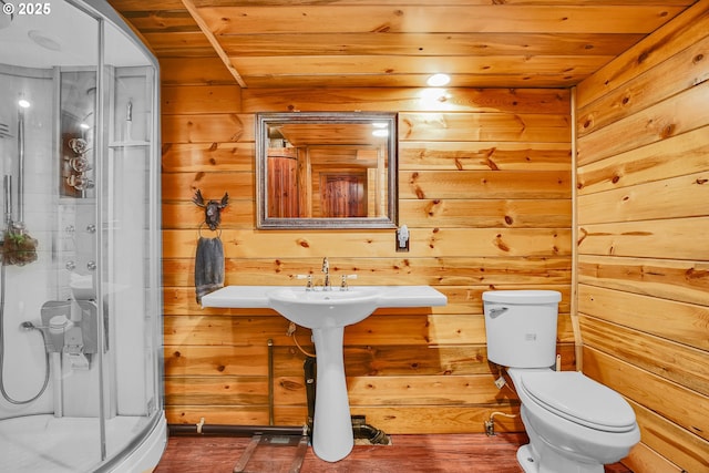 bathroom with a stall shower, wooden walls, toilet, and wood ceiling