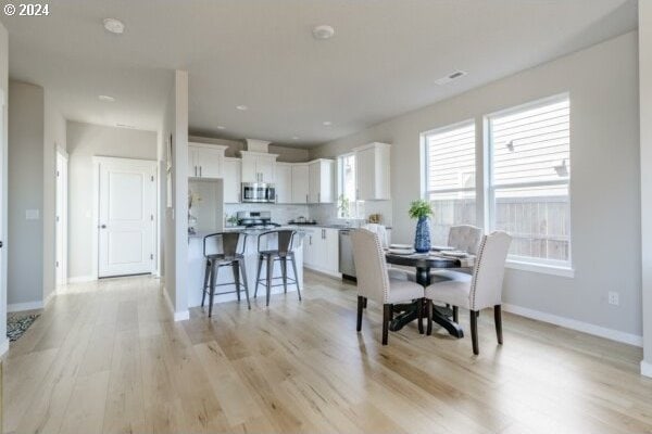 dining room with light wood-type flooring and plenty of natural light