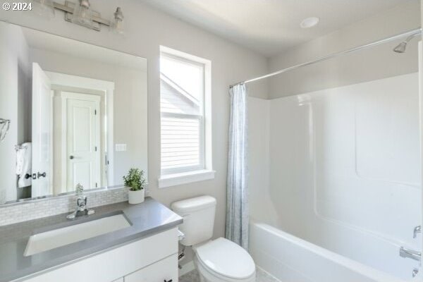 full bathroom featuring toilet, vanity, and shower / tub combo