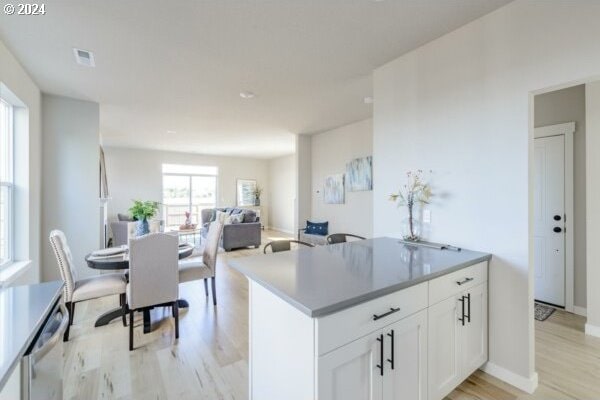 kitchen with light hardwood / wood-style floors, white cabinetry, and dishwasher