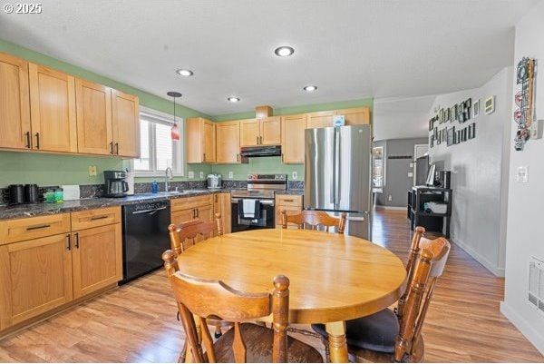 10514 NE 96th St, Vancouver, WA 98662 - kitchen with stainless steel appliances, under cabinet range hood, dark countertops, light brown cabinets, and light wood-style floors