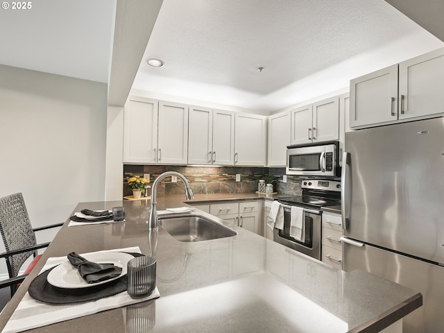 211 N Hayden Bay Dr Unit 211, Portland, OR 97217 - kitchen featuring stainless steel appliances, a sink, decorative backsplash, recessed lighting, and a peninsula