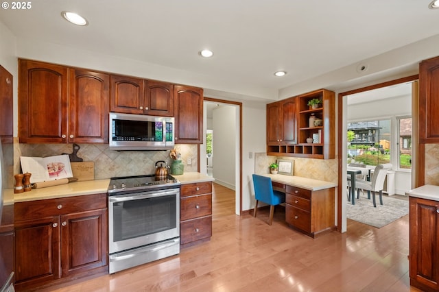 kitchen featuring stainless steel appliances, open shelves, light countertops, light wood-style flooring, and recessed lighting