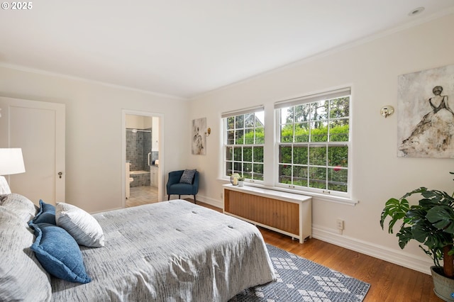 bedroom featuring radiator, ornamental molding, baseboards, wood finished floors, and connected bathroom